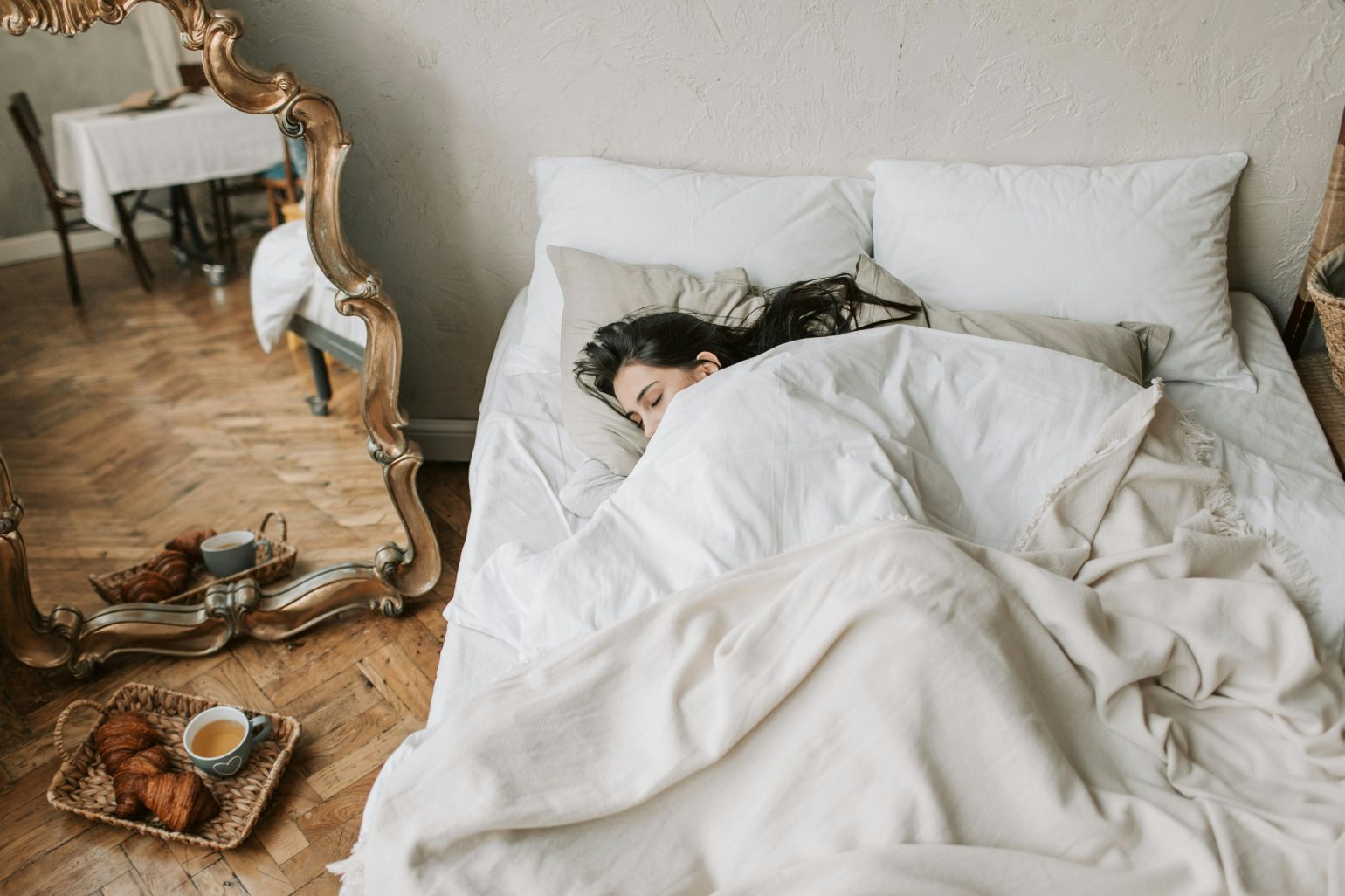 Woman having breakfast in bed next to a mirror